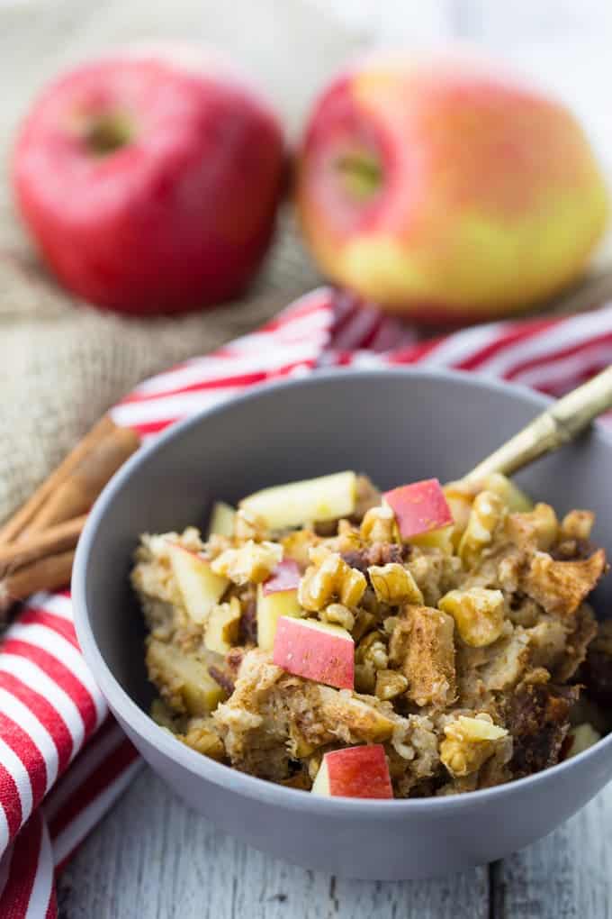 Slow Cooker Oats mit Quinoa, Apfel und Zimt in einer grauen Schüssel mit zwei Äpfeln im Hintergrund 