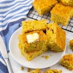 vier Stücke Maisbrot auf einem weißen Teller mit einem Messer nebendran