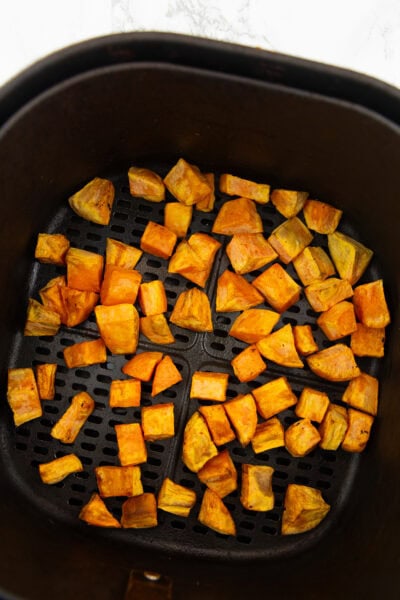Knusprige Süßkartoffelwürfel in einem Airfryer Korb