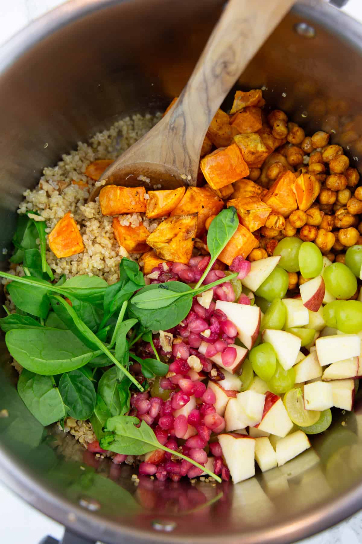 alle Zutaten für den Quinoa Süßkartoffel Salat in einer großen Schüssel mit einem Holzlöffel